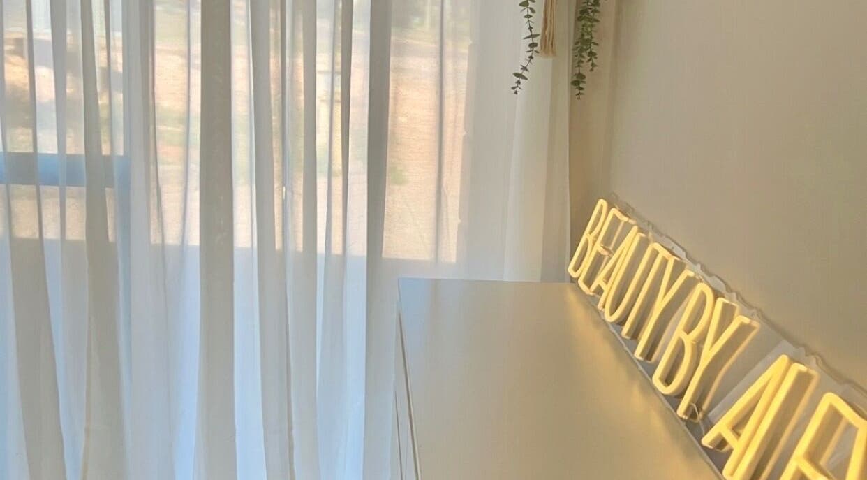 Bright, tranquil interior at Beauty by Alex Yeomans in Whyalla Norrie, South Australia, AU with a glowing sign.