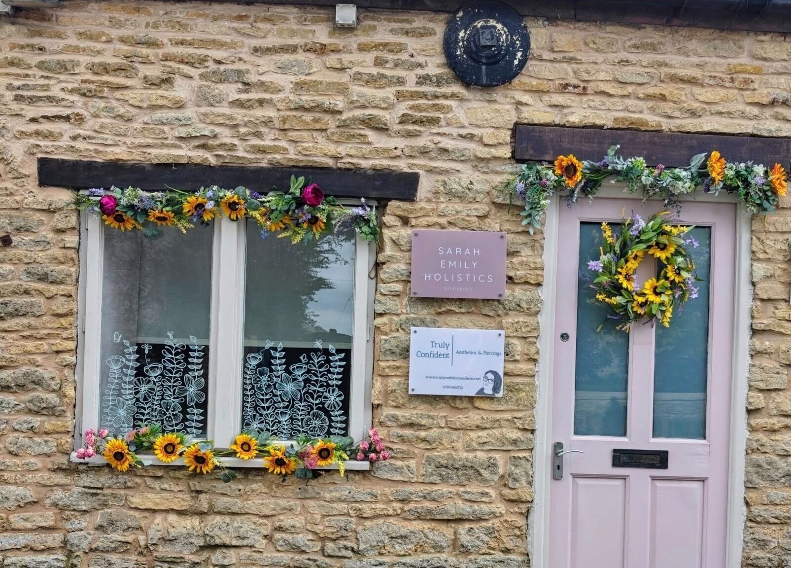 Entrance of Truly Confident Aesthetics in Helpston, England, GB, adorned with floral decorations.