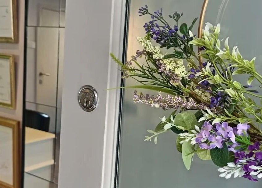 Entrance of Truly Confident Aesthetics in Helpston, England, GB, adorned with a vibrant floral wreath.