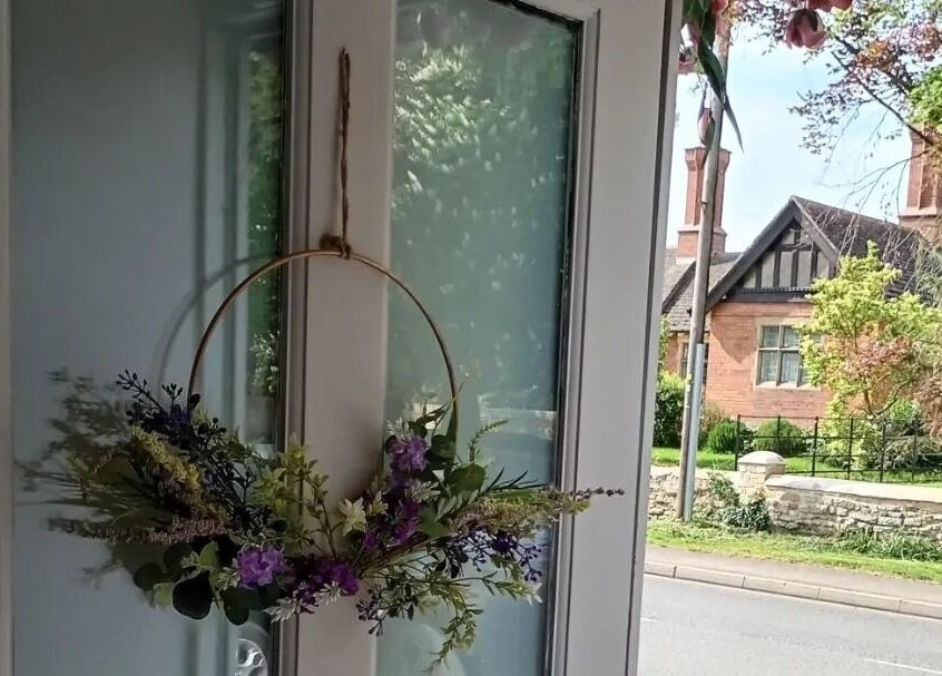 The entrance to Truly Confident Aesthetics in Helpston, England, GB features a door with a floral wreath.