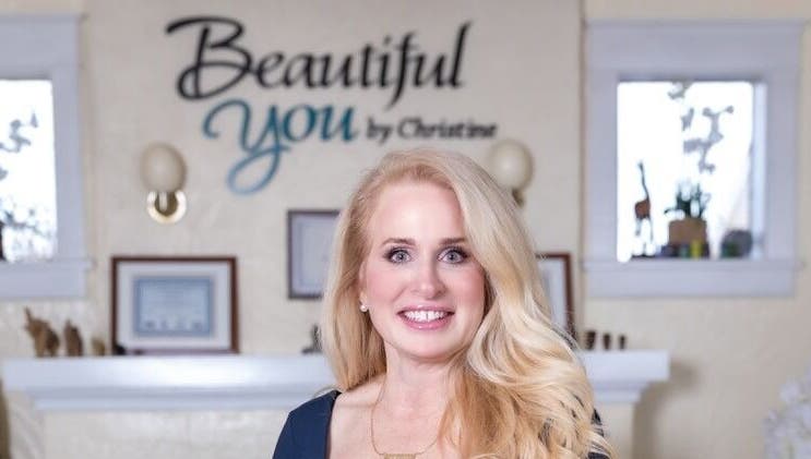 Owner of Beautiful You By Christine in Davidson, NC, stands smiling inside the welcoming spa venue.