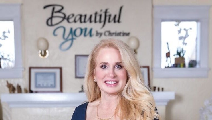 Owner of Beautiful You By Christine in Davidson, NC, stands smiling inside the welcoming spa venue.