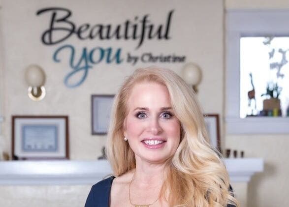 Owner of Beautiful You By Christine in Davidson, NC, stands smiling inside the welcoming spa venue.