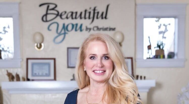 Owner of Beautiful You By Christine in Davidson, NC, stands smiling inside the welcoming spa venue.