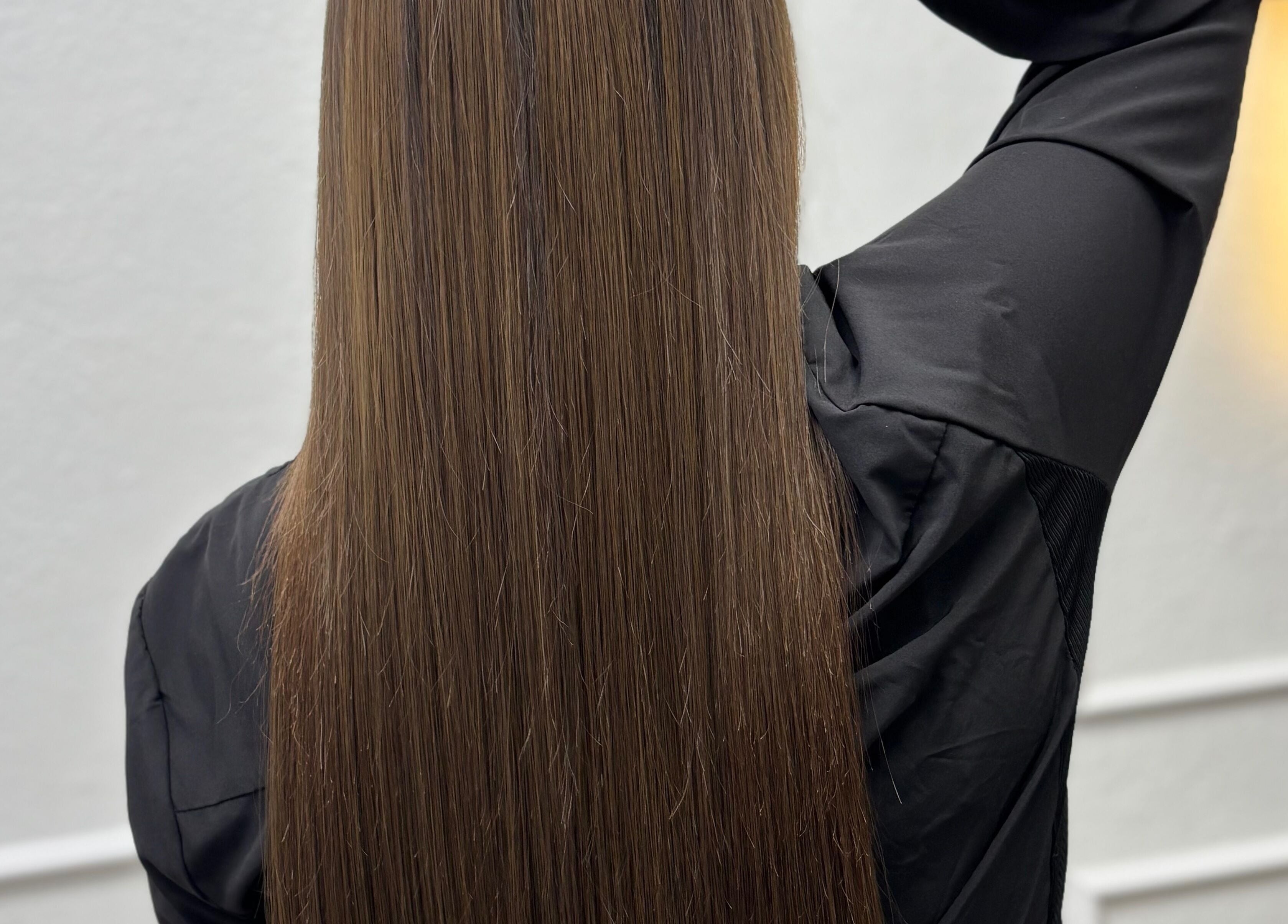 Sleek, long brown hair at Erika Lara salon, El Paso, Texas, US. Shiny and smooth style.