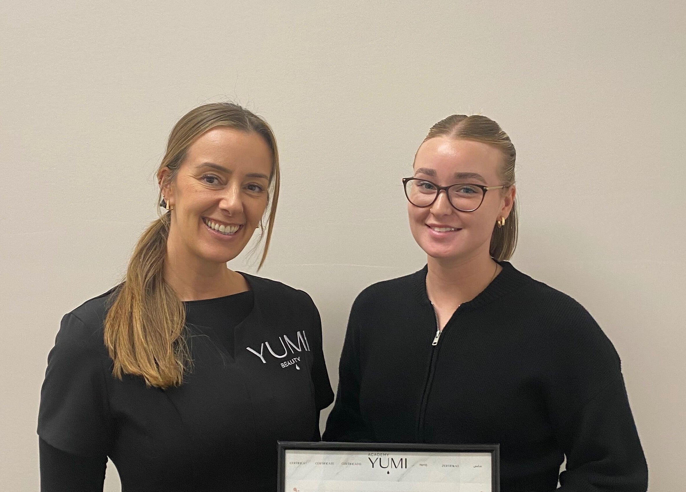 Two happy women at Arch & Curl Collective, Joondalup, Western Australia, AU with a certificate.