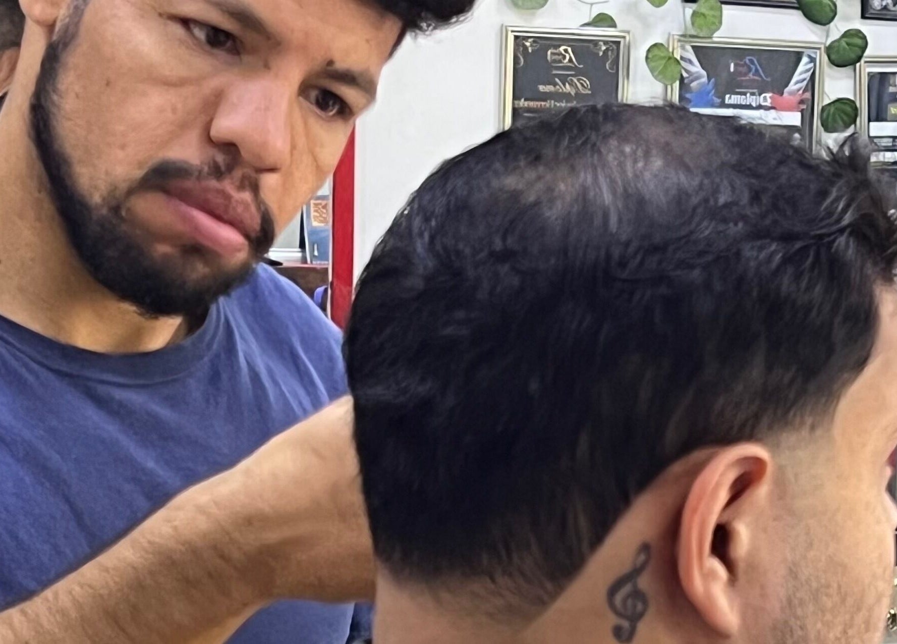 Estilista en Red Barber Studio, Hermosillo, Sonora, MX trabaja en un corte de cabello detallado.