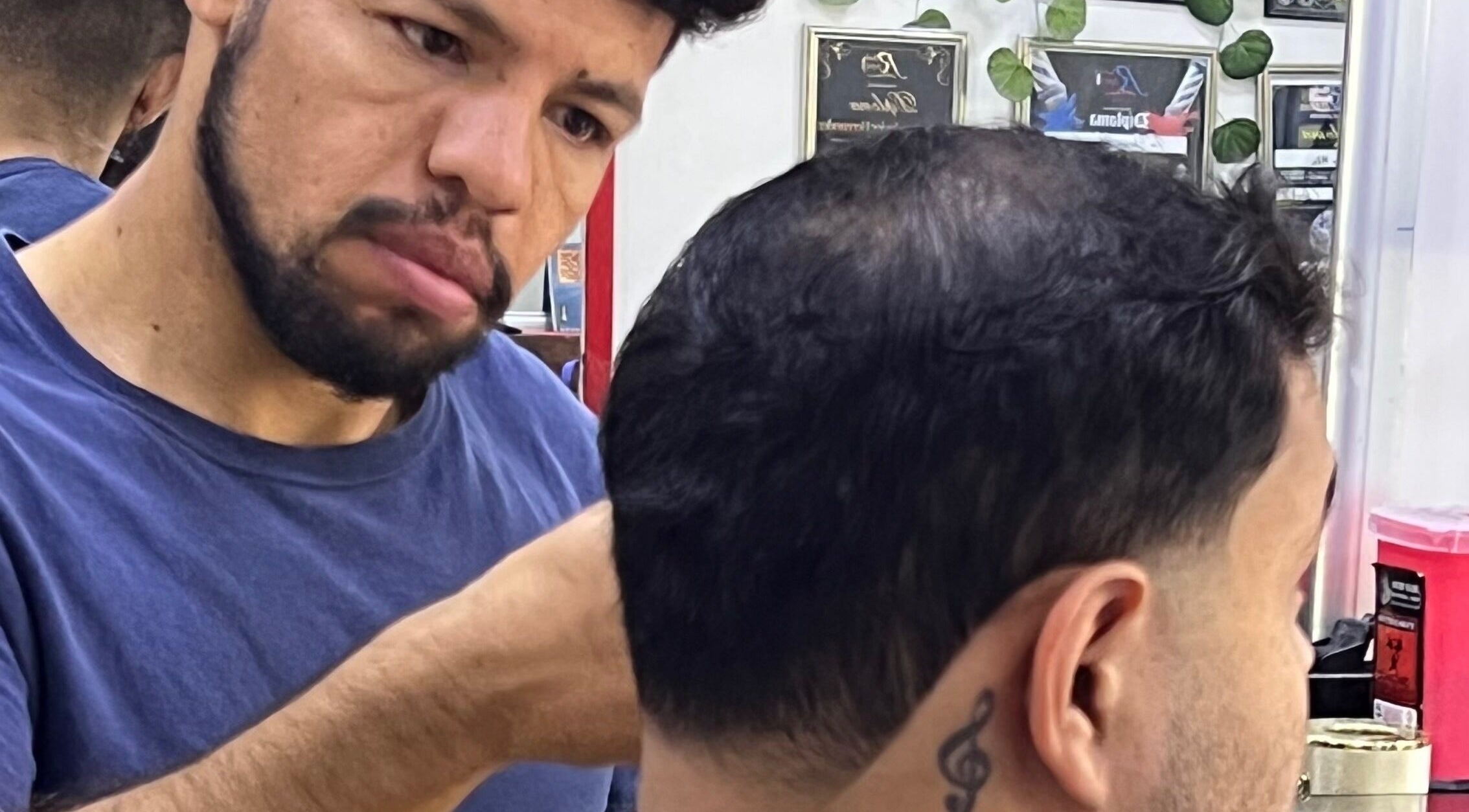 Estilista en Red Barber Studio, Hermosillo, Sonora, MX trabaja en un corte de cabello detallado.