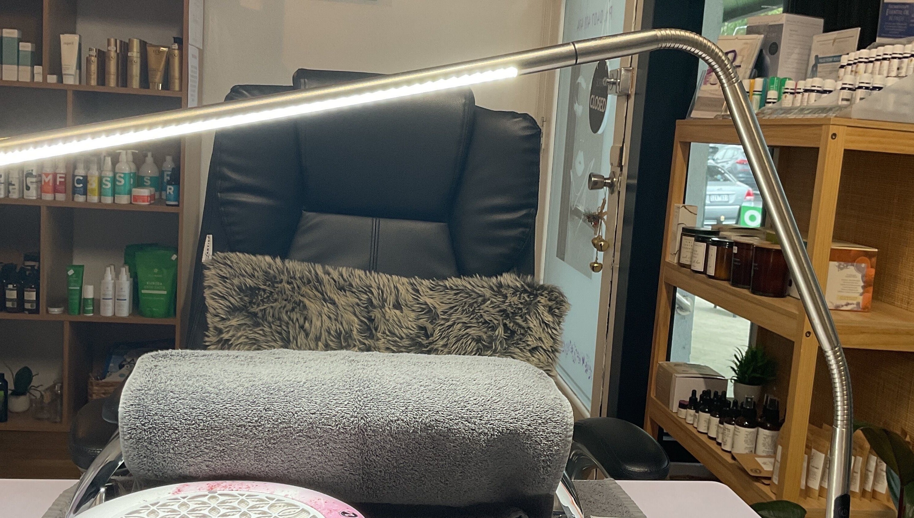 Comfortable nail station at Nails & More Salon, Maffra, Victoria, AU, with plush chair and organized shelves.