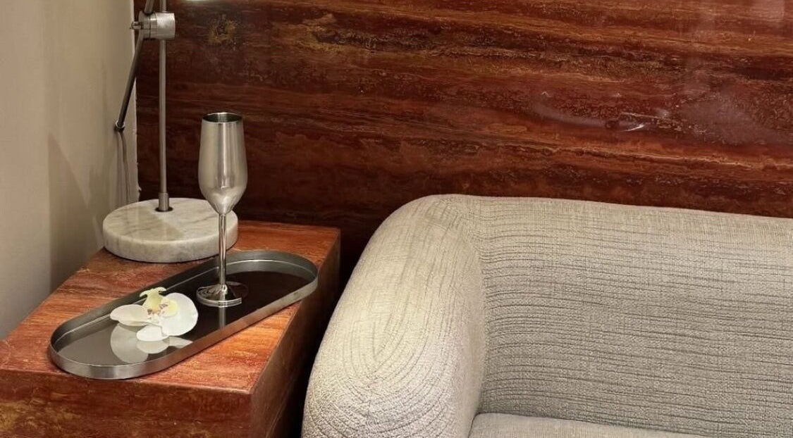 Elegant corner at Beyond Beauty, Ajman, showcasing a luxury lamp and armchair for relaxation.