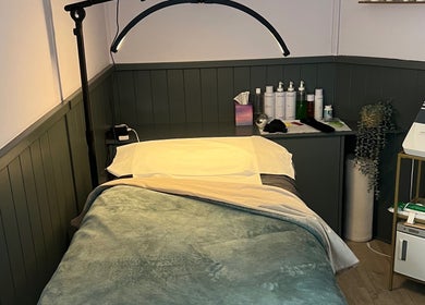 Cozy treatment room at The Beauty Cabin Reigate in Reigate, England, GB with bed and skincare products.