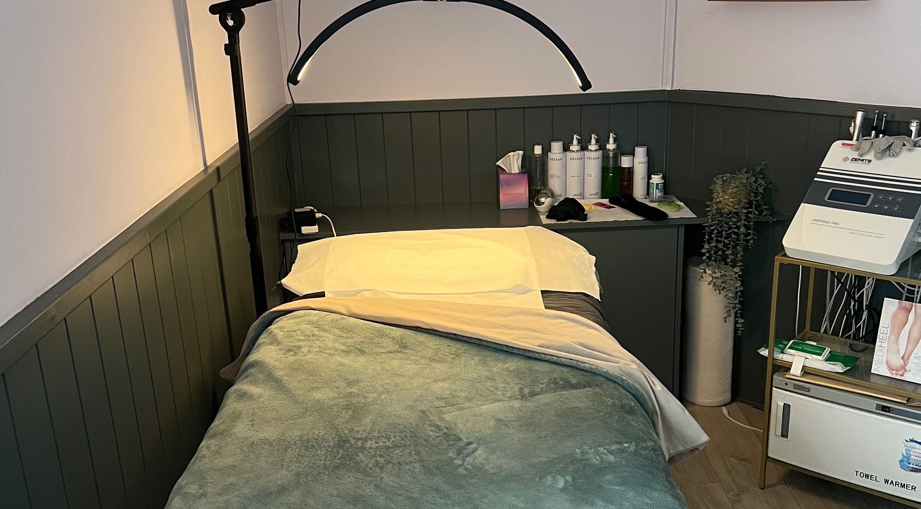 Cozy treatment room at The Beauty Cabin Reigate in Reigate, England, GB with bed and skincare products.