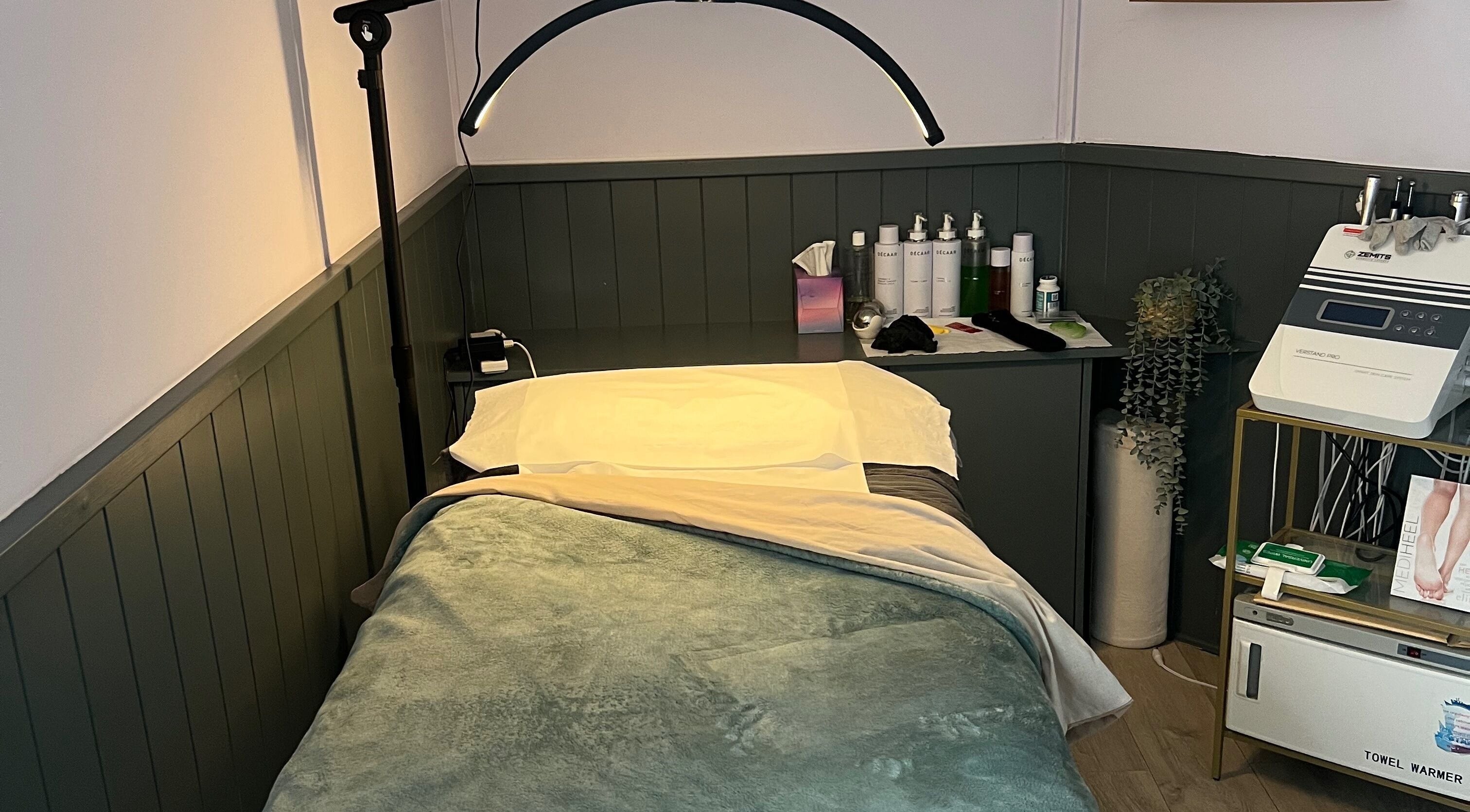 Cozy treatment room at The Beauty Cabin Reigate in Reigate, England, GB with bed and skincare products.