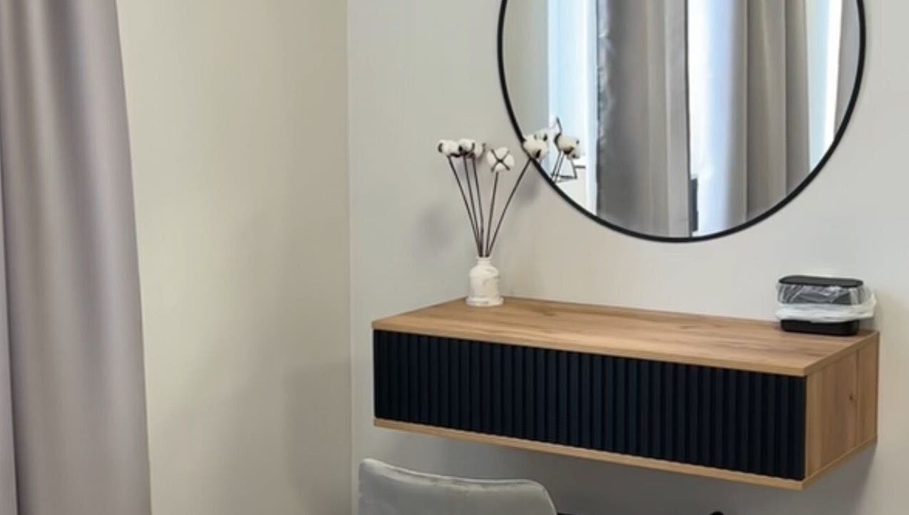 Modern vanity setup in Yaba with circular mirror and wooden shelf, located in Lagos, NG.