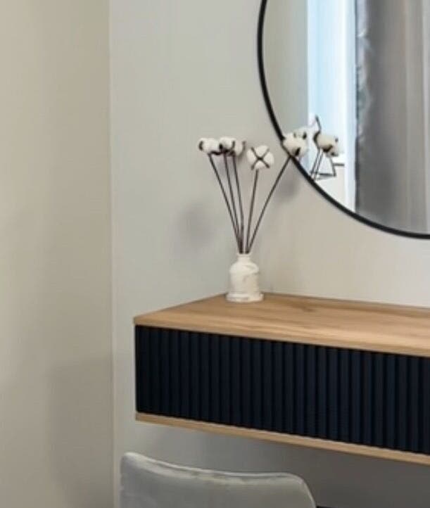 Modern vanity setup in Yaba with circular mirror and wooden shelf, located in Lagos, NG.