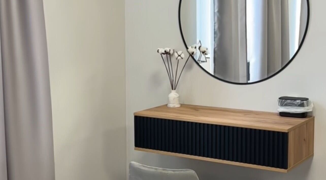 Modern vanity setup in Yaba with circular mirror and wooden shelf, located in Lagos, NG.