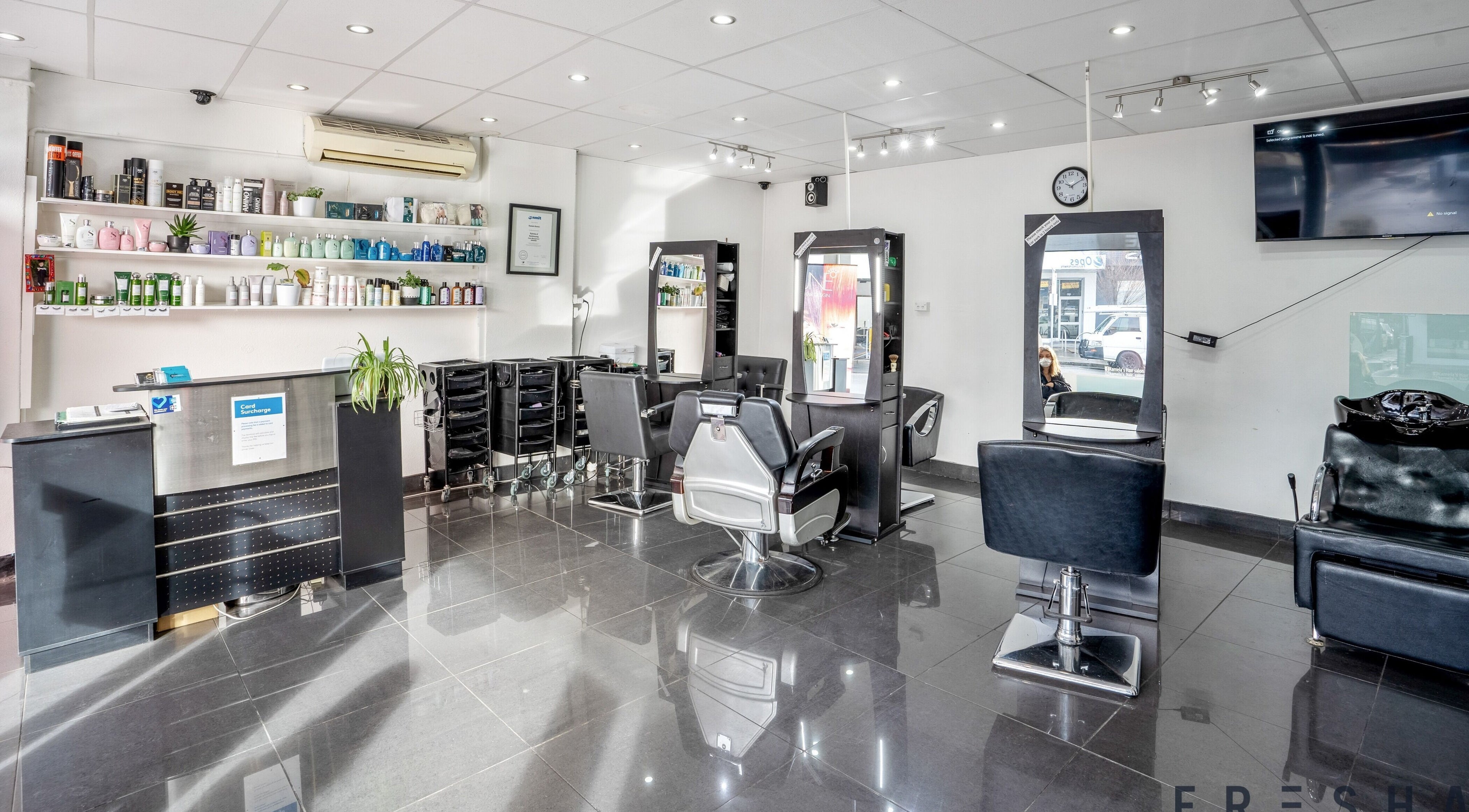 Modern interior of Kamela's Hair Salon in Melbourne, Victoria, AU, showcasing stylish chairs and a clean environment.