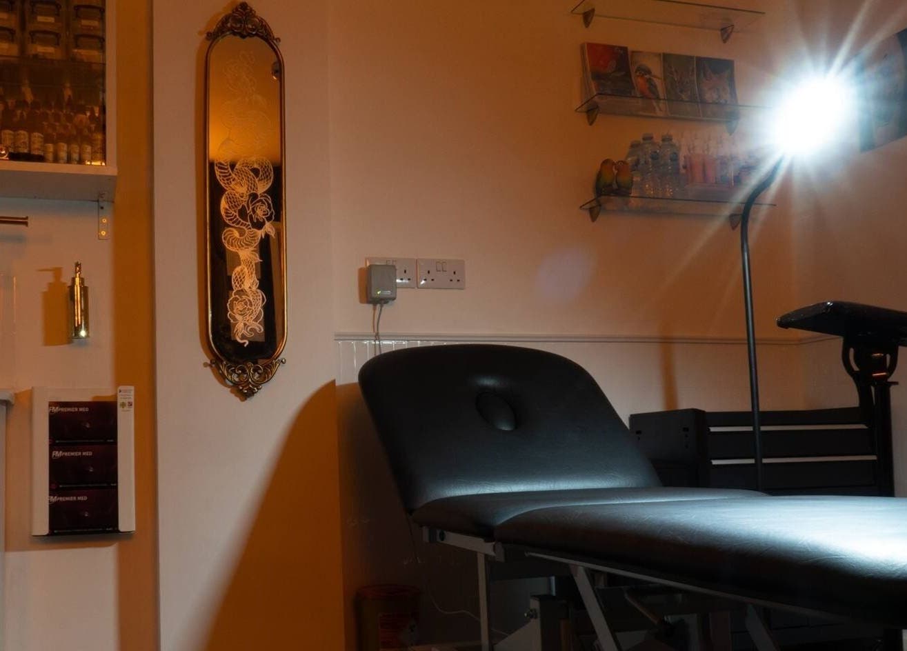 Cozy interior at Lucky Bird Tattoo Studio in Somerton, England, GB, showcasing a well-lit tattoo station.