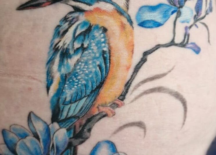 Colorful bird and flower tattoo at Lucky Bird Tattoo Studio, Somerton, England, GB.