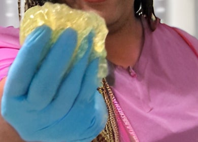 Therapist holding a golden sponge at Palangana Spa in Willemstad, Curaçao, CW, showcasing a luxurious treatment.