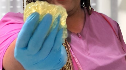 Therapist holding a golden sponge at Palangana Spa in Willemstad, Curaçao, CW, showcasing a luxurious treatment.