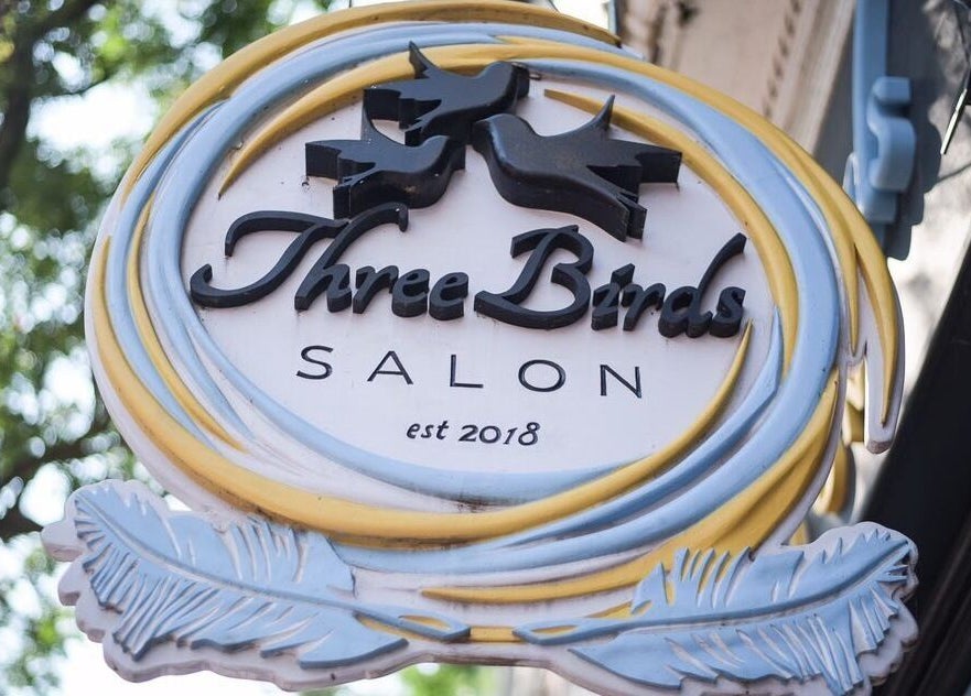 Sign of Three Birds Salon in Orillia, Ontario, CA, featuring a modern design with birds and feathers.