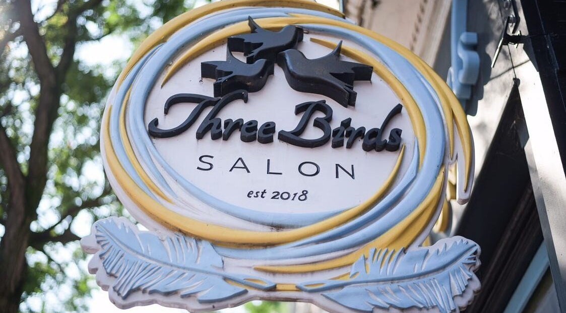 Sign of Three Birds Salon in Orillia, Ontario, CA, featuring a modern design with birds and feathers.