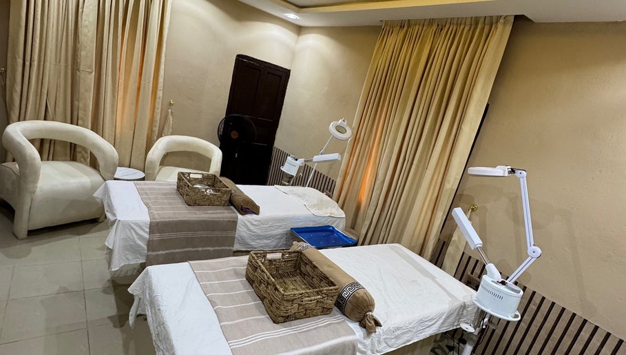 Relaxing treatment room at The Villa Spa in Awka, Anambra, NG featuring two massage tables and cozy seating.