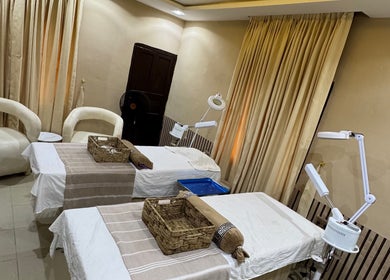 Relaxing treatment room at The Villa Spa in Awka, Anambra, NG featuring two massage tables and cozy seating.
