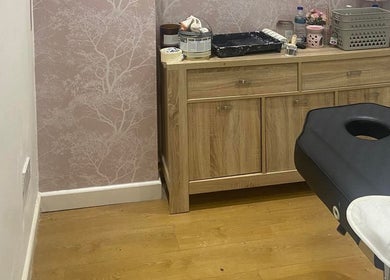Spa treatment room at The Blossom Lounge, Arbroath, Scotland, GB, with a massage table and wooden cabinet.