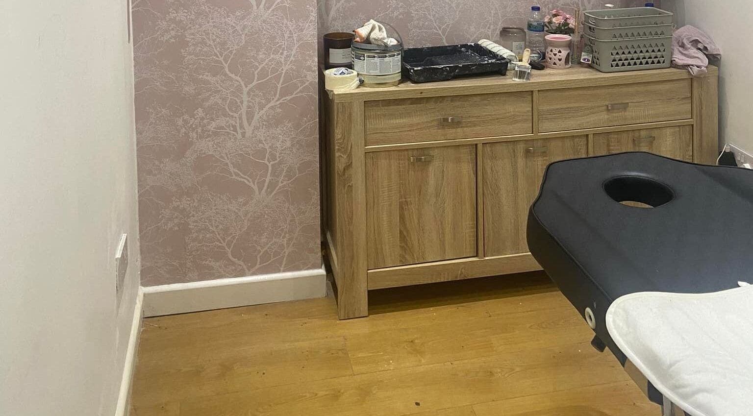 Spa treatment room at The Blossom Lounge, Arbroath, Scotland, GB, with a massage table and wooden cabinet.