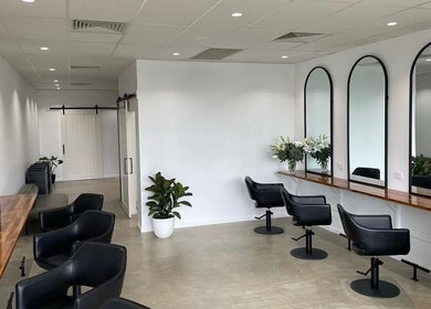 Modern salon interior with sleek mirrors and chairs at Mane Haus, Melbourne, Victoria, AU.