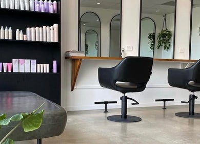 Modern salon interior at Mane Haus, Melbourne, Victoria, AU with stylish chairs and product display.