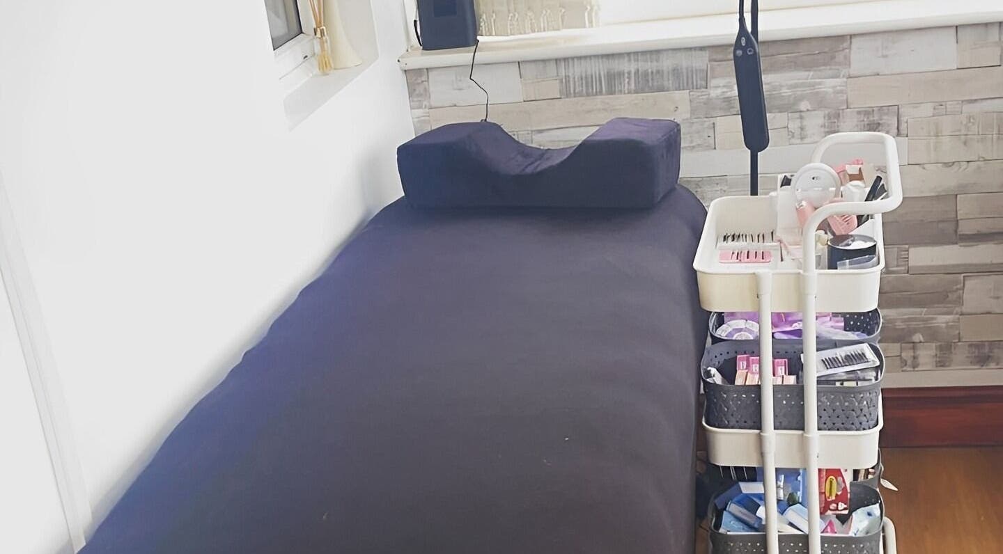 Treatment room in Lashes by Hayley, Morecambe, England, GB with a cozy bed and organized beauty cart.