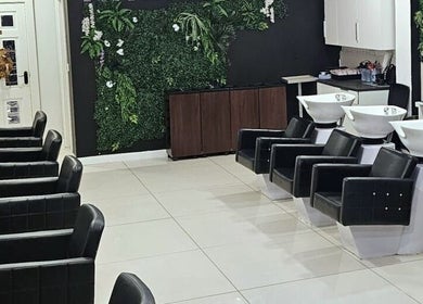 Modern interior of Kazanoo Hair Studio by Adrian in Galway, County Galway, IE, featuring sleek black chairs and greenery.