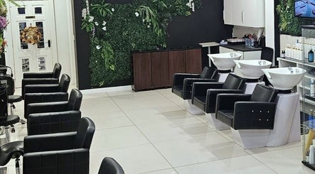 Modern interior of Kazanoo Hair Studio by Adrian in Galway, County Galway, IE, featuring sleek black chairs and greenery.