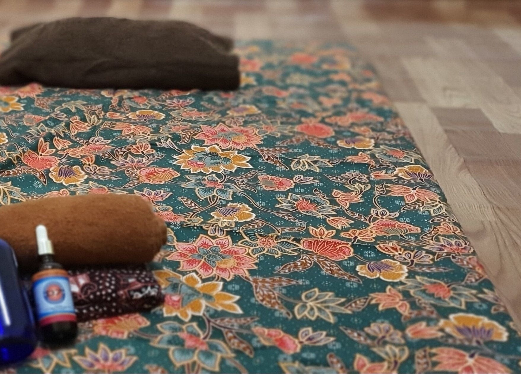 Colorful floral-patterned mat with wellness products at Teramu Terapi Alami, Seri Kembangan, Selangor, MY.