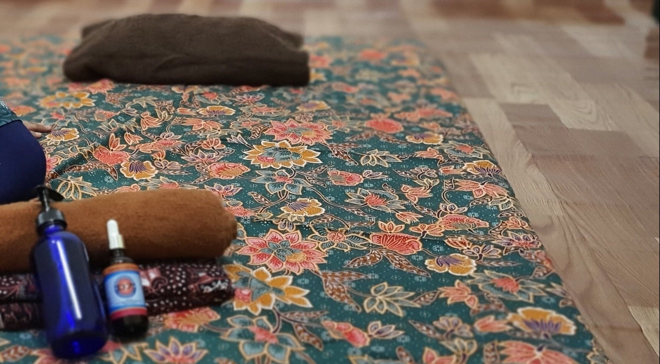 Colorful floral-patterned mat with wellness products at Teramu Terapi Alami, Seri Kembangan, Selangor, MY.