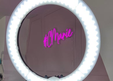 Ring light illuminating Charlotte Marie MUA & Nails neon sign in Farnworth, England, GB.