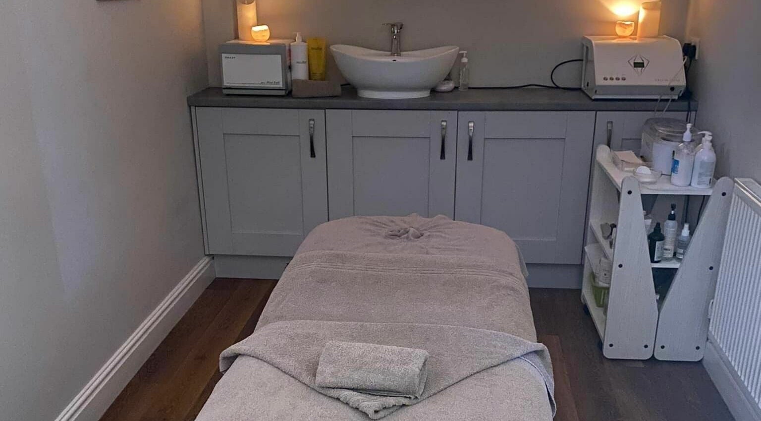 Relaxing treatment room at Indulgence Beauty Spa, Rhos on Sea, Wales, GB, featuring ambient candles and a massage table.