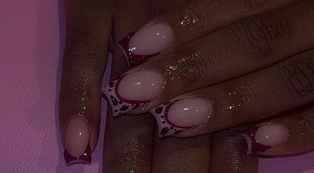 Stylish nail art at That Girl Collection in Ajax, CA showcasing intricate red and black patterns.