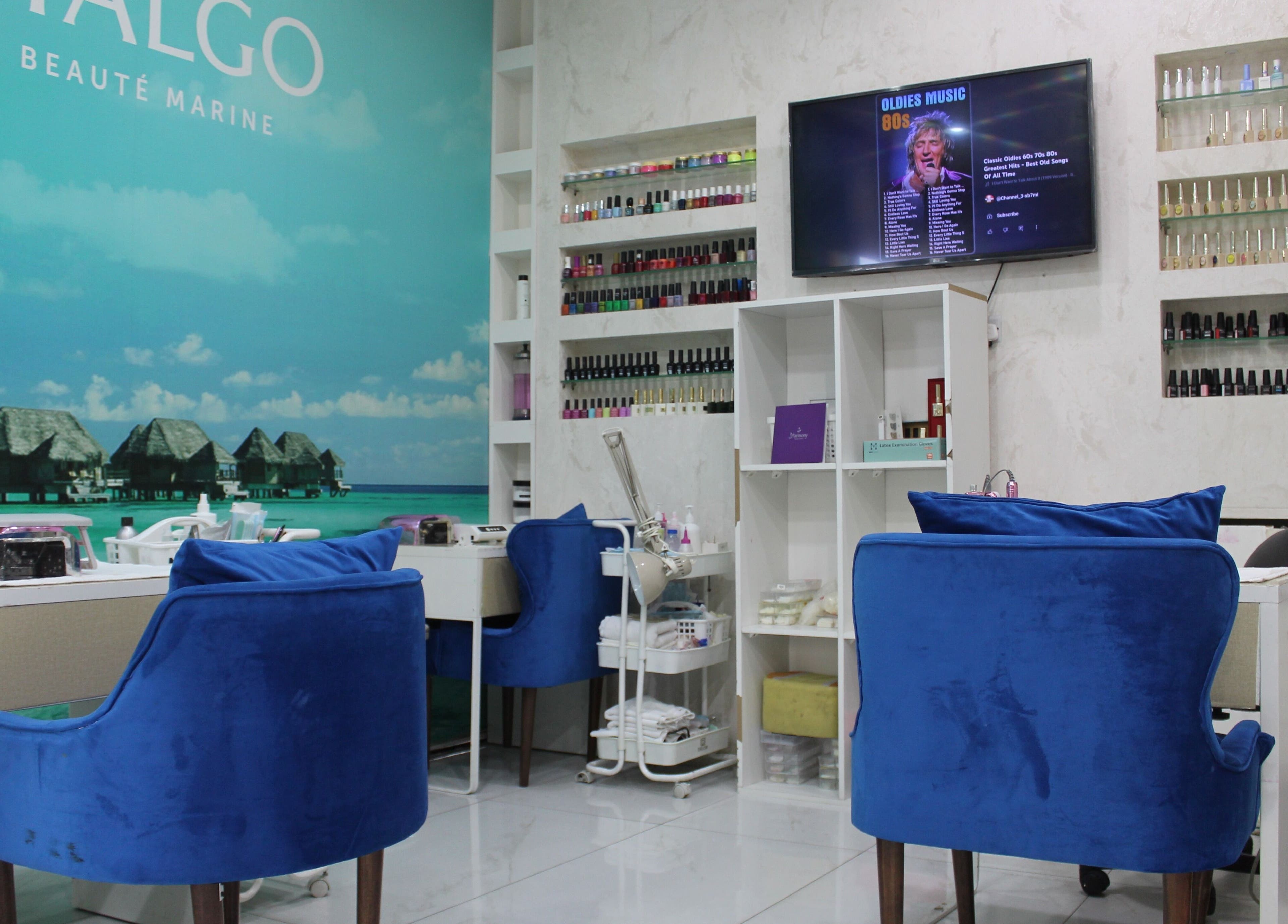 Relaxing interior of Harmony Ladies Salon in Dubai, Dubai, AE with stylish blue seating and nail polish display.