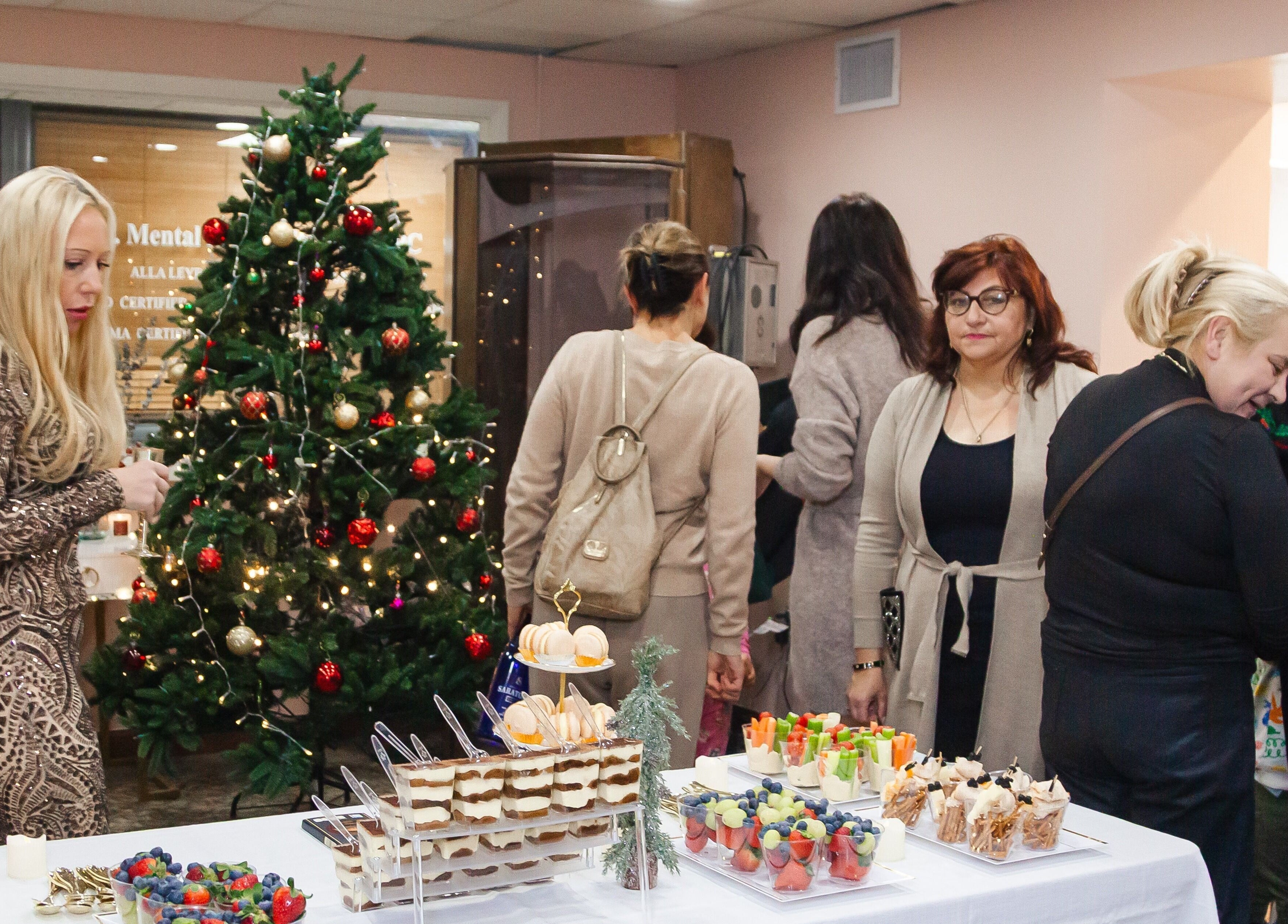 Festive event at Zen Beauty Lounge, Stroudsburg, Pennsylvania, US, with a decorated tree and assorted desserts.