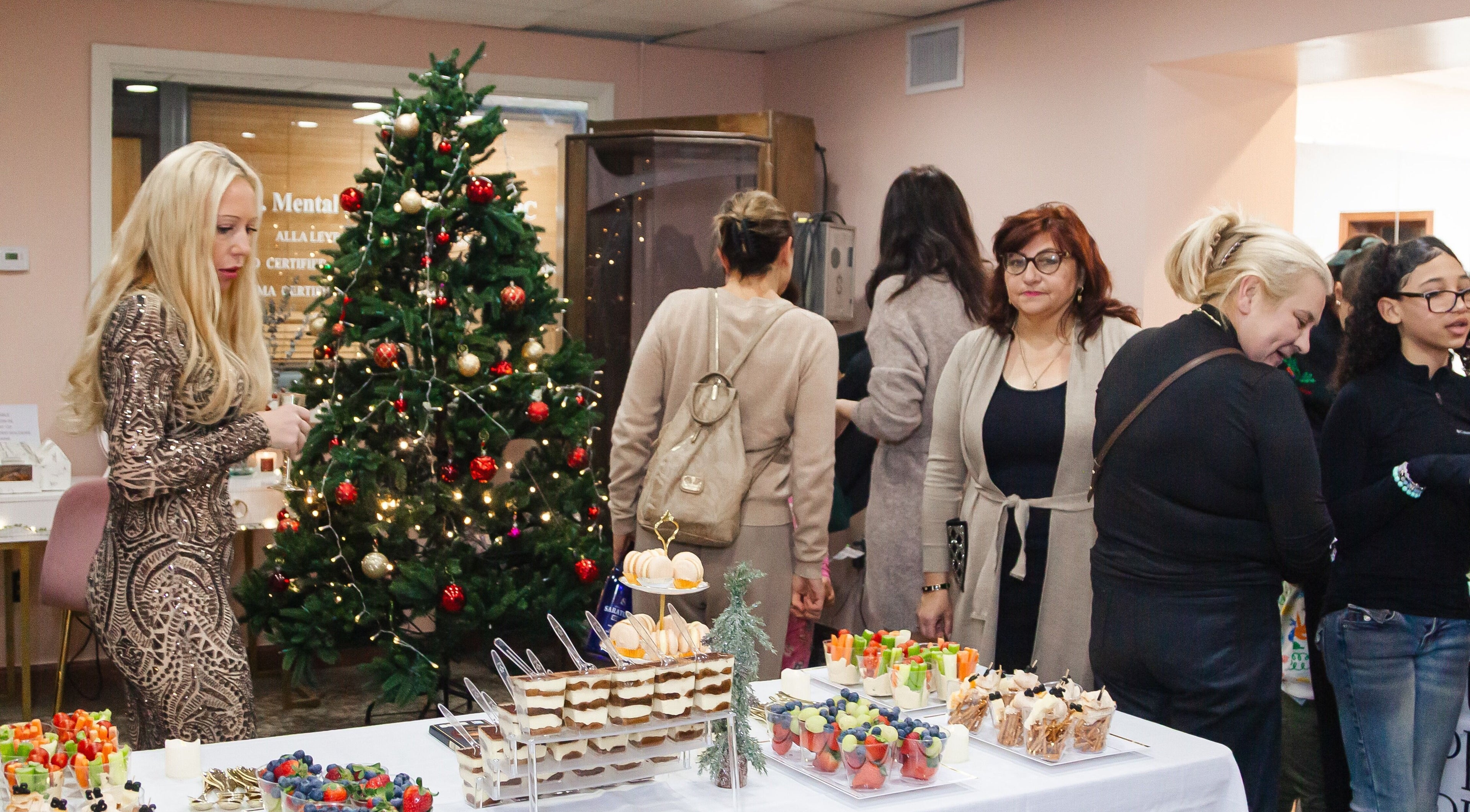 Festive event at Zen Beauty Lounge, Stroudsburg, Pennsylvania, US, with a decorated tree and assorted desserts.