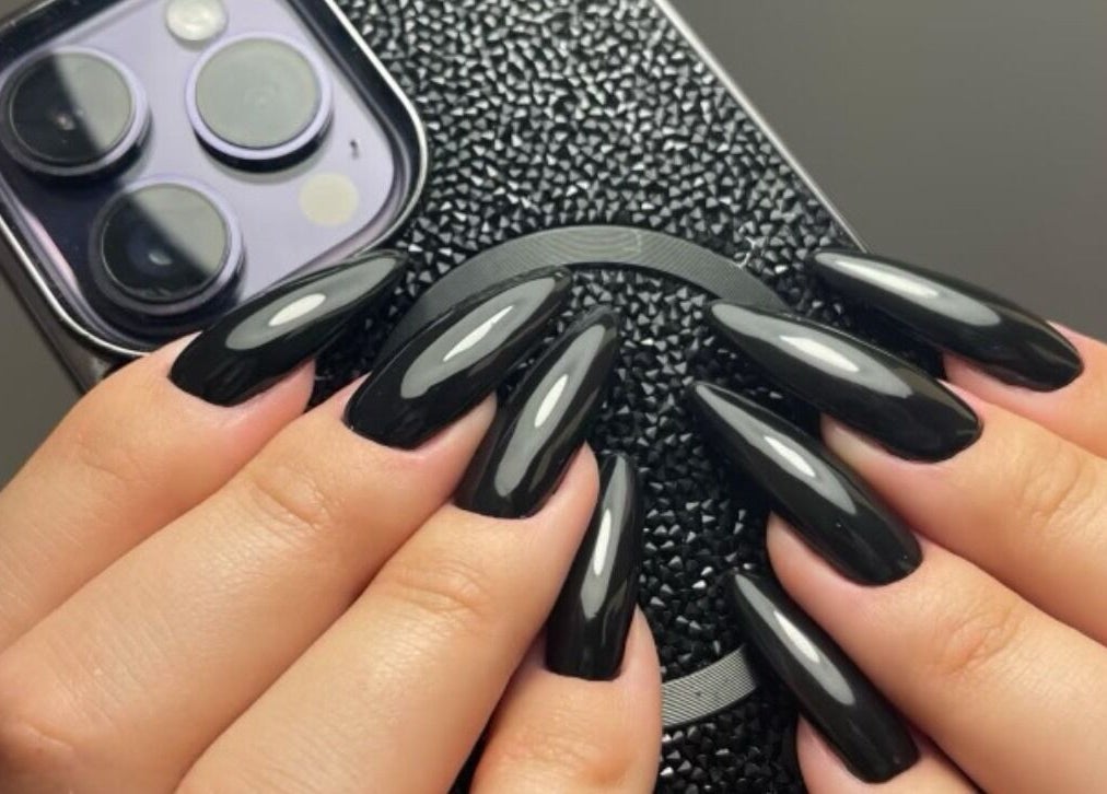 Sleek black almond-shaped nails at Zen Beauty Lounge, Stroudsburg, Pennsylvania, US, showcasing nail artistry.