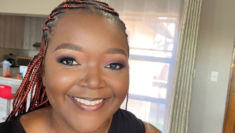Smiling woman with braided hair at Touch by Thato Pretoria, Gauteng, ZA, exuding confidence and charm.