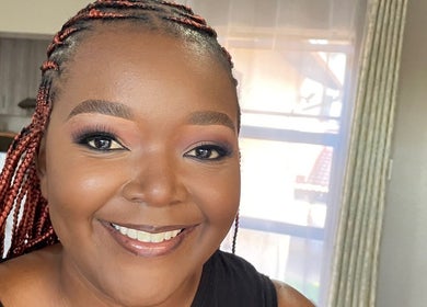 Smiling woman with braided hair at Touch by Thato Pretoria, Gauteng, ZA, exuding confidence and charm.