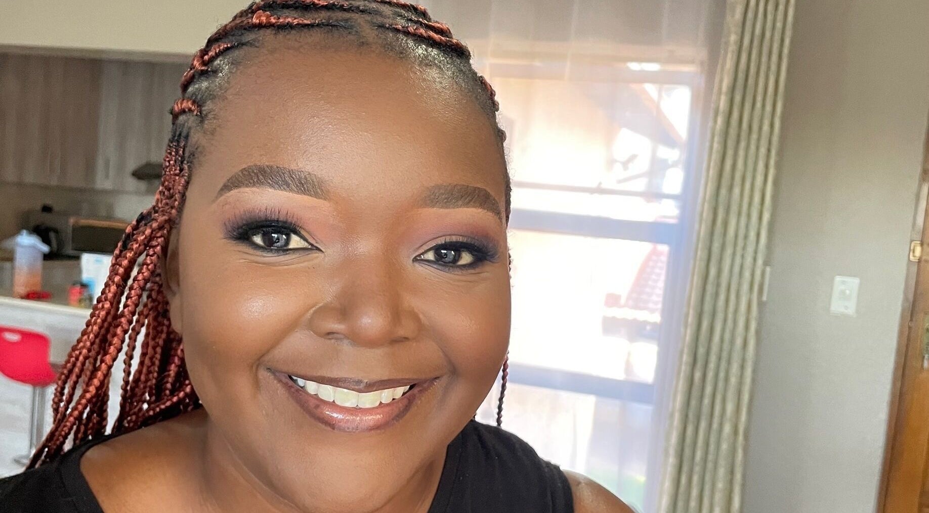 Smiling woman with braided hair at Touch by Thato Pretoria, Gauteng, ZA, exuding confidence and charm.