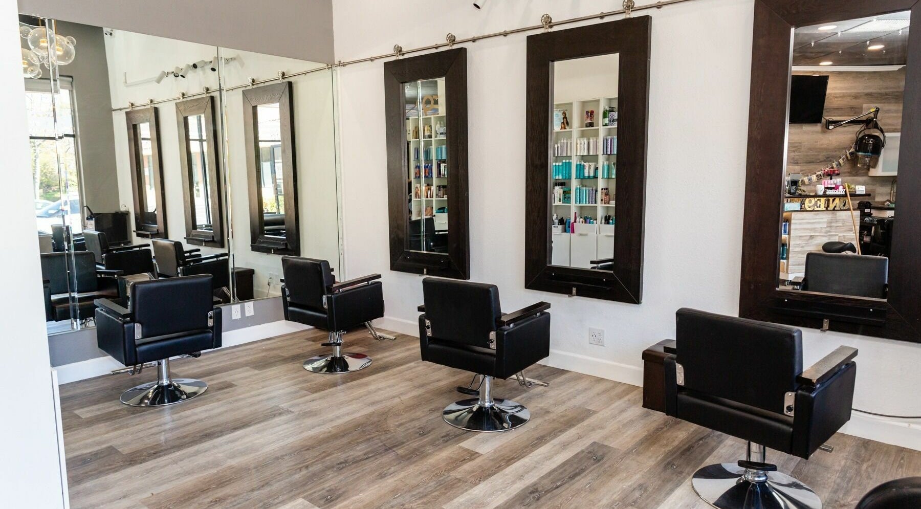Elegant salon interior at Salon One 9, Walnut, California, US with modern styling chairs and large mirrors.