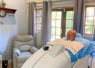 A man enjoys steam therapy at Ozone Clinic Cape Town, Western Cape, ZA in a serene room setting.